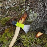 Una destral adaptada amb un mecanisme d'inserció recolzada a la base d'un arbre. Aquesta eina s'utilitza per introduir de forma ràpida i precisa els xips de radiofreqüència (RFID) de Simtrona a la fusta.