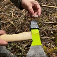 Detall de la col·locació manual d'un xip RFID al suport d'inserció de la destral especialitzada abans de procedir al marcatge del tronc.